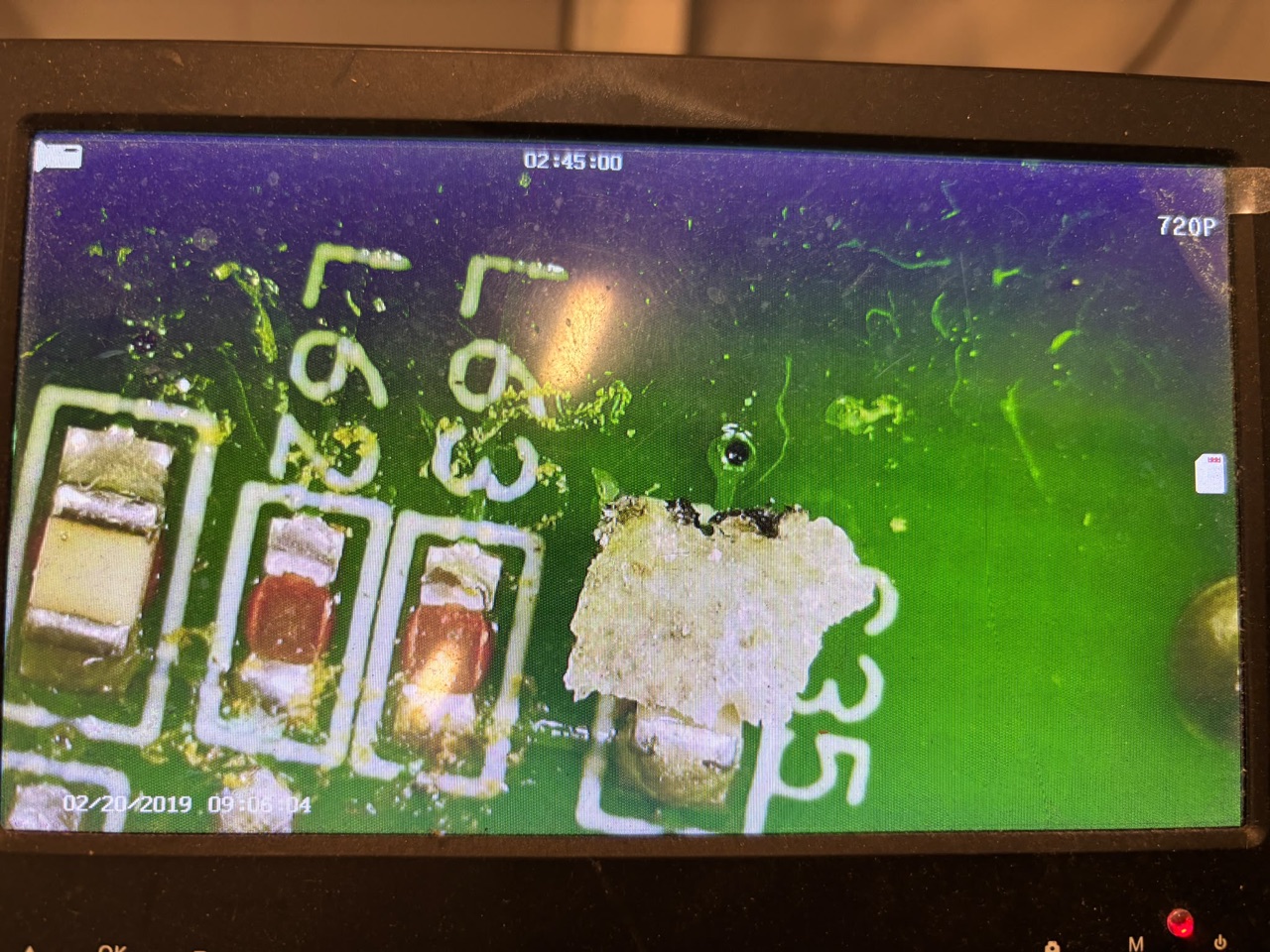 Microscoopbeeld van de VCU-print: corrosie en doorgeslagen sporen rond de signaalingang