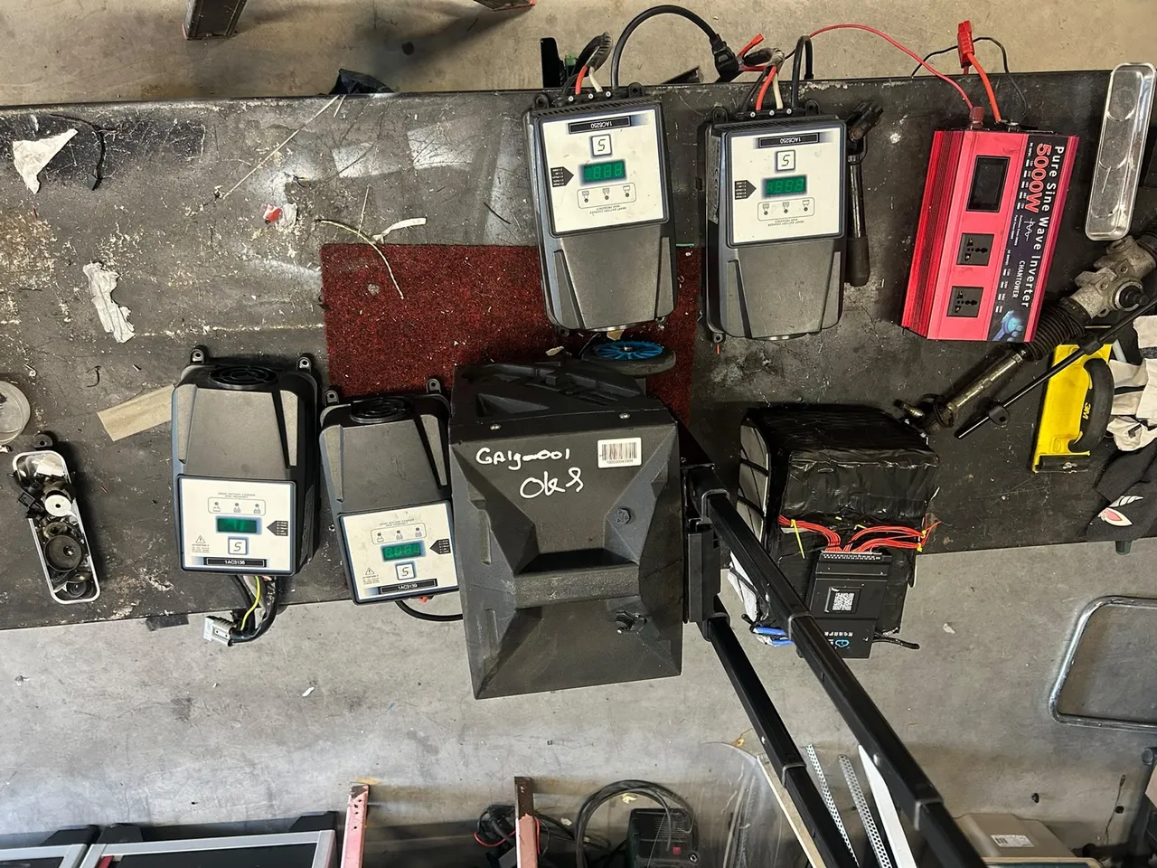Vier Birò-laders, een Re-Move accupack en een geopend accupack op de Voltron werkbank in Weesp