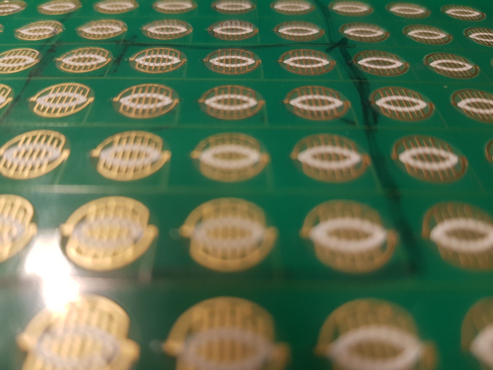 Gold-plated pressure-sensor cells on a production PCB panel, pre-depanel